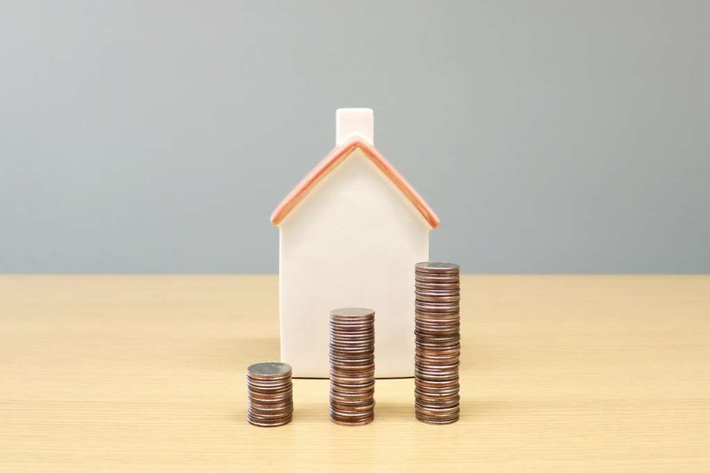 A model house beside stacks of coins, representing an AI property valuation