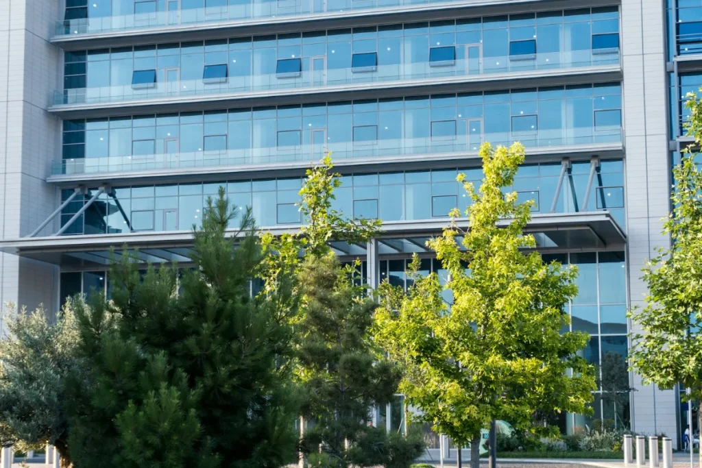 Modern glass office building with trees in front